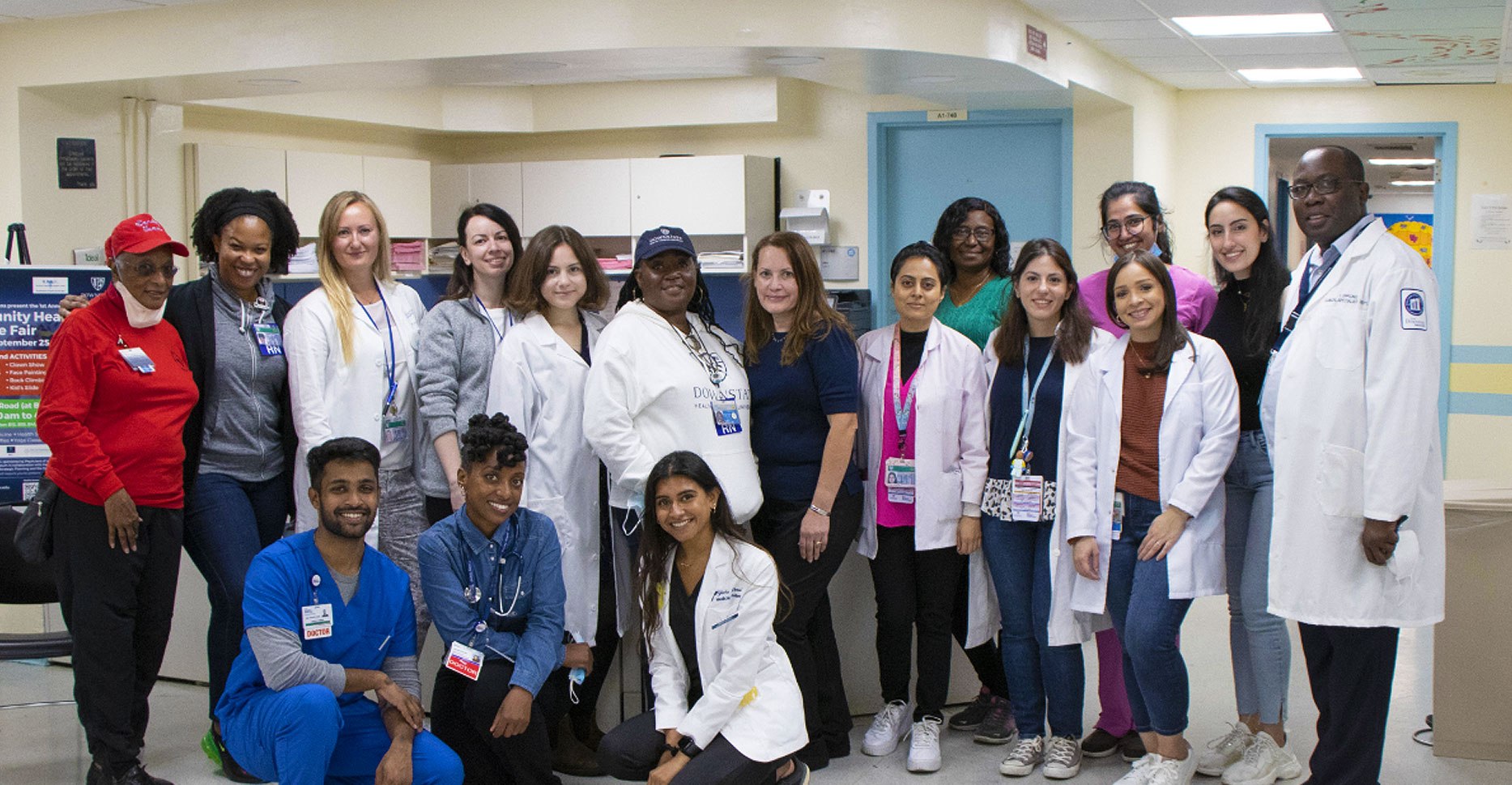 SUNY Downstate Health Sciences doctors and students pose for a picture in a hospital hallway after a health fair finished.